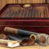 smoking accessories Quality cigars and other accessories such as cigar cutters, matches and cigar etui on a wooden table. In the background a humidor in front of a wooden wall. Concentrate on the cigars